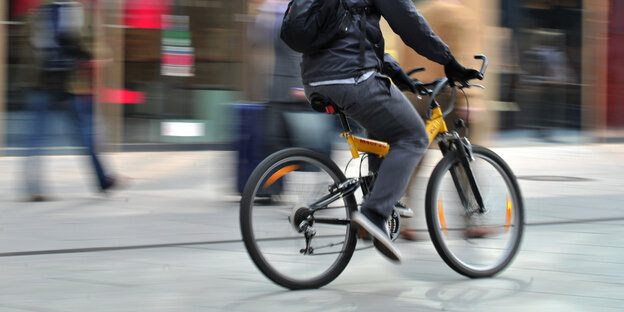 Ein Fahrradfahrer fährt durch eine Fußgängerzone