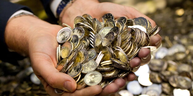 Hände, gefüllt mit 2-Euro-Münzen Hände, gefüllt mit 2-Euro-Münzen