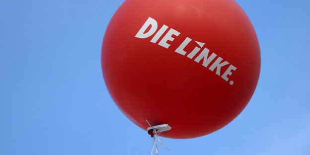 ein roter Luftballon mit der Aufschrift „Die Linke“ vor blauem Himmel ein roter Luftballon mit der Aufschrift „Die Linke“ vor blauem Himmel