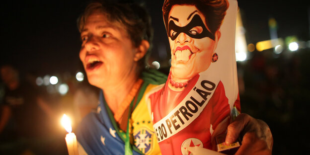 Eine Protestlerin, sie hält Kerzen und ein Schild mit Dilma Rousseff Eine Protestlerin, sie hält Kerzen und ein Schild mit Dilma Rousseff