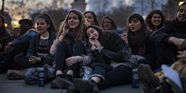 Junge Menschen sitzen auf dem Boden Junge Menschen sitzen auf dem Boden