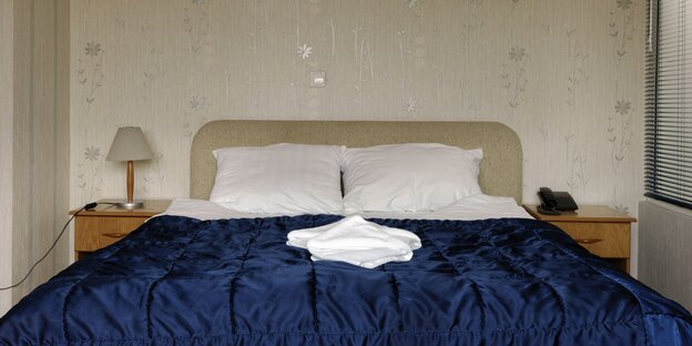 Doppelbett mit blauem Überwurf Doppelbett mit blauem Überwurf
