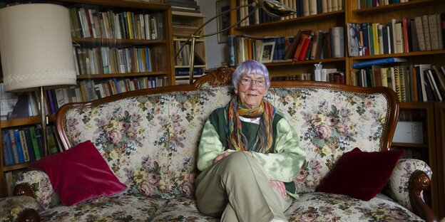 Eine Frau sitzt auf einem Sofa Eine Frau sitzt auf einem Sofa