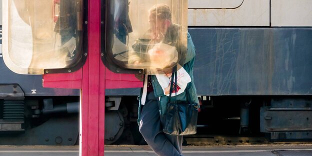 Eine Frau telefobniert an der Telefonzelle Eine Frau telefobniert an der Telefonzelle