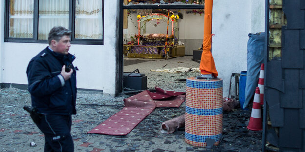 Ein Polizist steht vor dem zerstörten Sikh-Tempel in Essen Ein Polizist steht vor dem zerstörten Sikh-Tempel in Essen