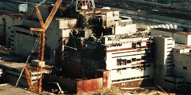 Ein Kran steht neben dem havarierten Reaktor in Tschernobyl Ein Kran steht neben dem havarierten Reaktor in Tschernobyl
