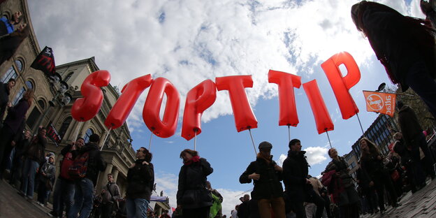 Menschen halten Ballons hoch, die Schriftzug „Stop TTIP“ ergeben Menschen halten Ballons hoch, die Schriftzug „Stop TTIP“ ergeben