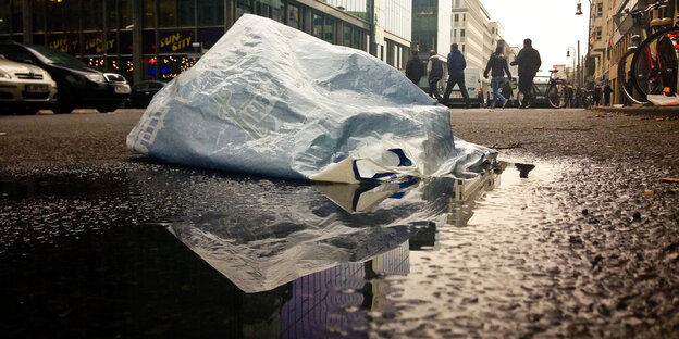 Eine Plastiktüte auf regennasser Straße Eine Plastiktüte auf regennasser Straße