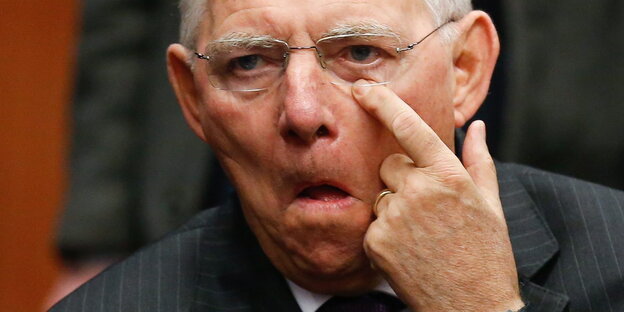 Wolfgang Schäuble hält seinen linken Zeigefinger an sein linkes Auge Wolfgang Schäuble hält seinen linken Zeigefinger an sein linkes Auge