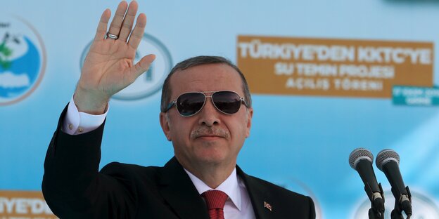 Herr Erdoğan im Anzug mit Sonnenbrille und erhobener Hand Herr Erdoğan im Anzug mit Sonnenbrille und erhobener Hand