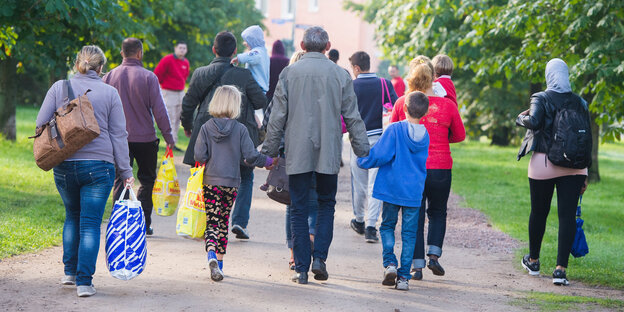 Von hinten zu sehen: eine Gruppe Menschen in bunter Kleidung Von hinten zu sehen: eine Gruppe Menschen in bunter Kleidung
