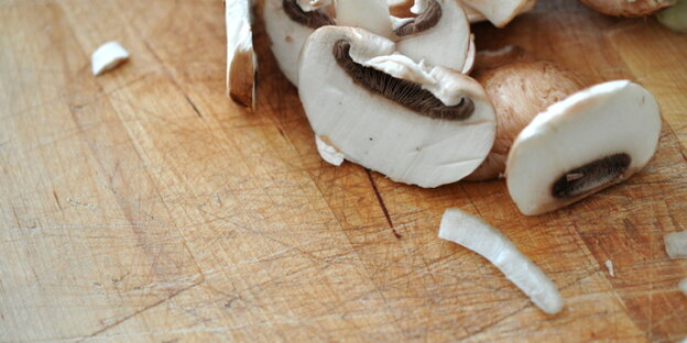 Geschnittene Champignons auf einem Holzbrett