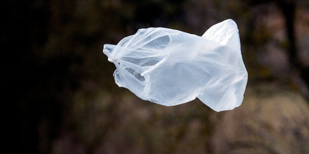 Eine weiße Plastiktüte fligt durch eine dunkle Landschaft Eine weiße Plastiktüte fligt durch eine dunkle Landschaft