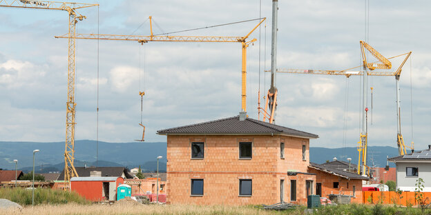 Haus im Rohbau, im Hintergrund Baukräne Haus im Rohbau, im Hintergrund Baukräne