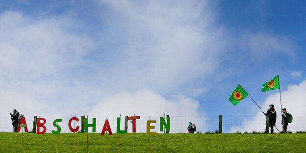 Auf grüner Wiese vor blauem Himmel steht in buten Buchstaben „Abschalten“ Auf grüner Wiese vor blauem Himmel steht in buten Buchstaben „Abschalten“