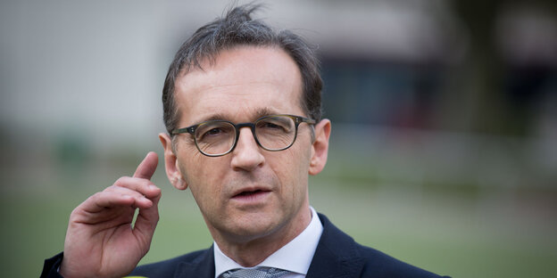 Porträt Heiko Maas, der eine hand an sein rechtes Ohr legt Porträt Heiko Maas, der eine hand an sein rechtes Ohr legt