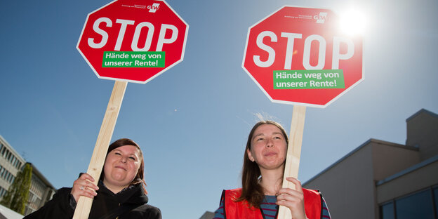 Zwei Frauen mit Stopschildern Zwei Frauen mit Stopschildern