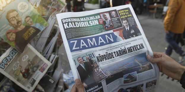 An einem Zeitungsstand hält ein Mensch die Zeitung „Zaman“ in den Händen An einem Zeitungsstand hält ein Mensch die Zeitung „Zaman“ in den Händen