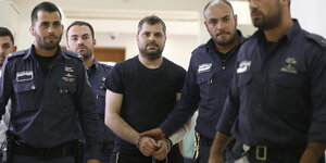 Ben-David wird von vier israelischen Poizisten ins Gericht eskortiert.