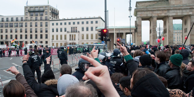 Zwei Demonstrationsgruppen stehen sich am Brandenburger Tor gegenüber, getrennt von Gittern und Polizei Zwei Demonstrationsgruppen stehen sich am Brandenburger Tor gegenüber, getrennt von Gittern und Polizei