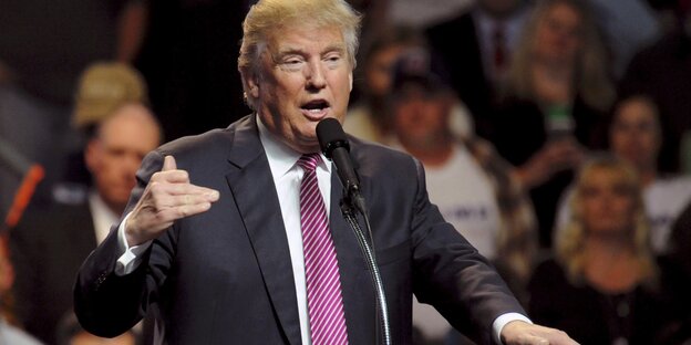 Ein Mann steht an einem Pult. Es ist Donald Trump Ein Mann steht an einem Pult. Es ist Donald Trump