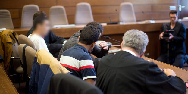 Fünf Männer sitzen an einem Tisch Fünf Männer sitzen an einem Tisch