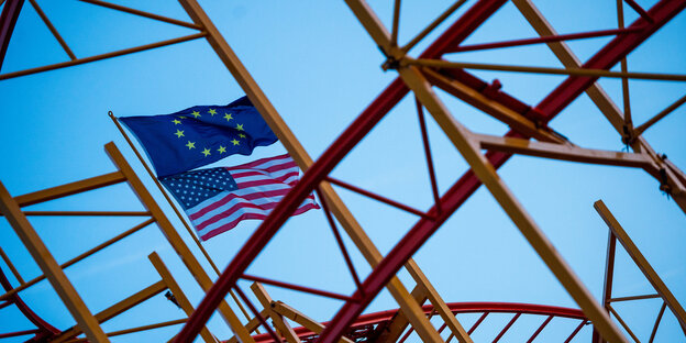 An einem Achterbahngerüst angebrachte Flaggen der EU und der USA An einem Achterbahngerüst angebrachte Flaggen der EU und der USA