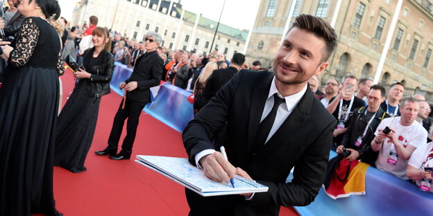 Der russische ESC-Kandidat Sergej Lazarev gibt ein Autogramm auf dem roten Teppich in Stockholm