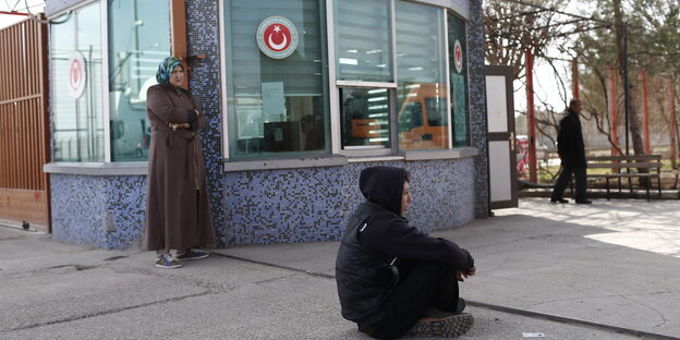 Ein Junge und eine Frau warten an einem Kontrollpunkt an der syrisch-türkischen Grenze