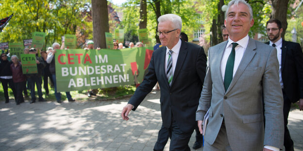 Winfried Kretschmann und Thomas Strobel laufen an Ceta-Gegner_innen vorbei Winfried Kretschmann und Thomas Strobel laufen an Ceta-Gegner_innen vorbei
