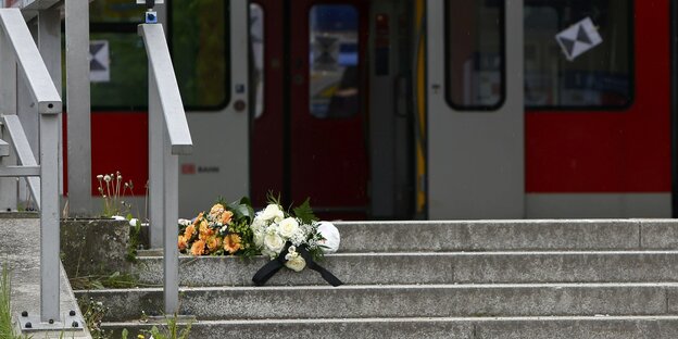 Blumen liegen am Bahnhof Grafing auf der Treppe zum Bahnsteig