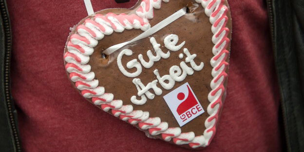 Ein Demonstrant trägt ein Lebkuchenherz mit der Aufschrift: Gute Arbeit Ein Demonstrant trägt ein Lebkuchenherz mit der Aufschrift: Gute Arbeit