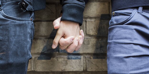 Zwei Männer halten sich an der Hand Zwei Männer halten sich an der Hand