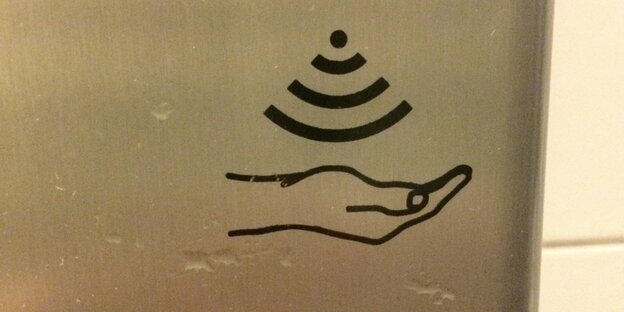 Ein Seifenspender mit einem WLAN-artigen Piktogramm und einer Hand darunter Ein Seifenspender mit einem WLAN-artigen Piktogramm und einer Hand darunter