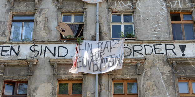 An einer grauen Hauswand hängt ein Transparent mit der Aufschrift „Kein Platz für Neuvermietung“ An einer grauen Hauswand hängt ein Transparent mit der Aufschrift „Kein Platz für Neuvermietung“