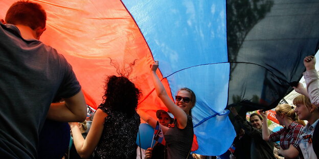 Menschen unter einer Flagge in Rot-Blau-Schwarz Menschen unter einer Flagge in Rot-Blau-Schwarz