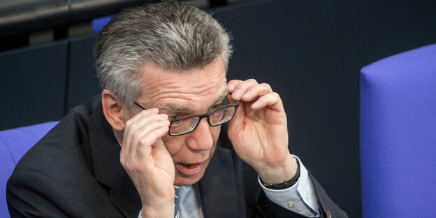 Thomas de Maiziére fasst sich an die Brille Thomas de Maiziére fasst sich an die Brille