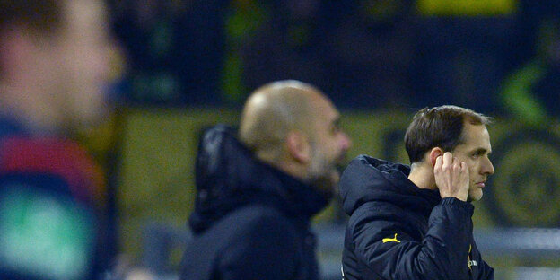 Zwei Trainer, Guardiola (unscharf) und Tuchel, am Spielfeldrand Zwei Trainer, Guardiola (unscharf) und Tuchel, am Spielfeldrand