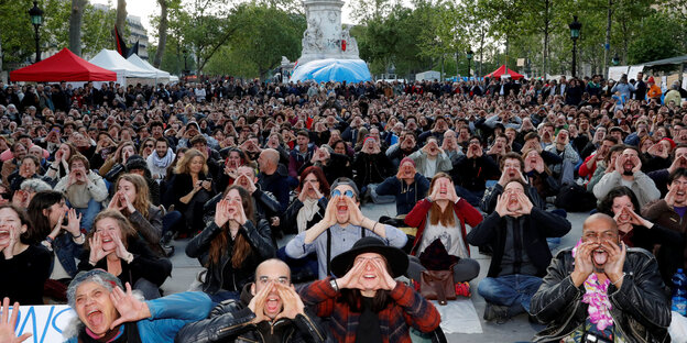 Nuit-Debout-Unterstützer sitzen auf dem Boden und halten die Hände zum Sprechtrichter geformt Nuit-Debout-Unterstützer sitzen auf dem Boden und halten die Hände zum Sprechtrichter geformt