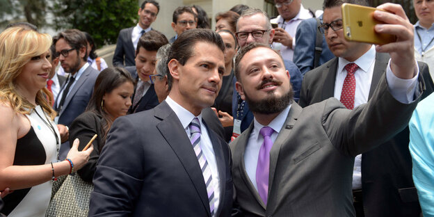 Enrique Pena Nieto (links) posiert für ein Selfie mit einem Mann Enrique Pena Nieto (links) posiert für ein Selfie mit einem Mann