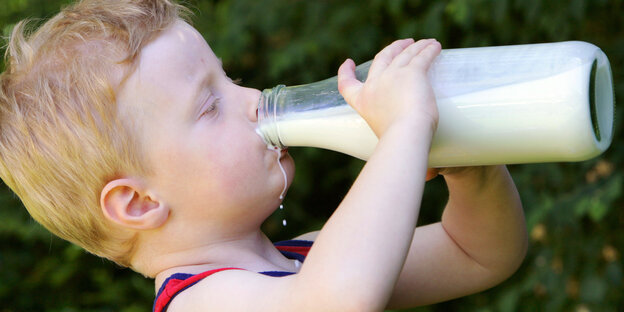 Ein Kind trinkt Milch aus einer Flasche Ein Kind trinkt Milch aus einer Flasche