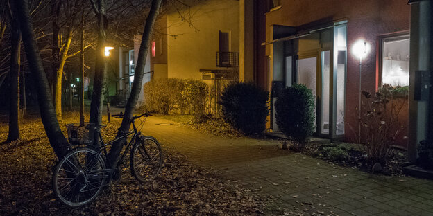 Ein Fahrrad lehnt im Dunkeln an einem Baum Ein Fahrrad lehnt im Dunkeln an einem Baum
