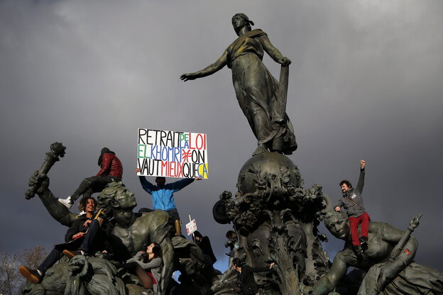 Menschen mit einem Plakat auf einer Statue Menschen mit einem Plakat auf einer Statue