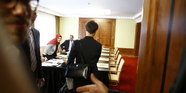 Eine Frau betritt ein Besprechungszimmer Eine Frau betritt ein Besprechungszimmer