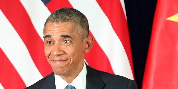 Barack Obama steht vor US- und vietnamesischen Flaggen Barack Obama steht vor US- und vietnamesischen Flaggen