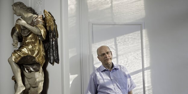 Ein Mann neben einer Engelsstatue Ein Mann neben einer Engelsstatue