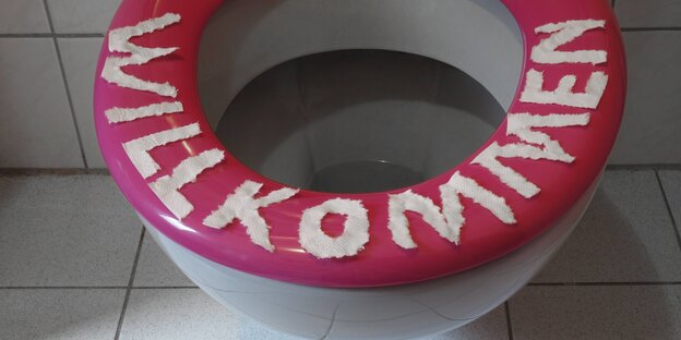 Ein Toilettenrand, auf den mit Buchstaben aus Klopapier das Wort "Willkommen" gelegt wurde Ein Toilettenrand, auf den mit Buchstaben aus Klopapier das Wort "Willkommen" gelegt wurde