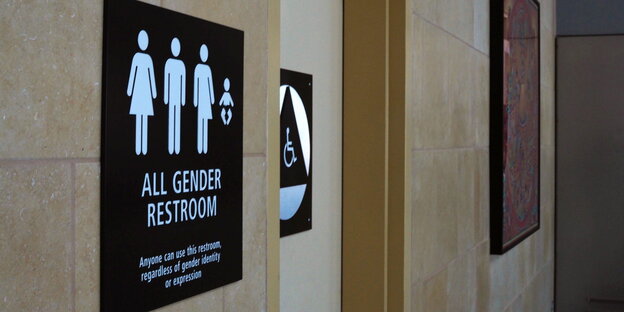 Schild vor einer Toilettentür für alle Geschlechter Schild vor einer Toilettentür für alle Geschlechter