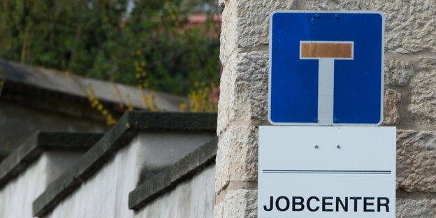 Ein Sackgassenschild über einem Schild, auf dem "Jobcenter" steht Ein Sackgassenschild über einem Schild, auf dem "Jobcenter" steht
