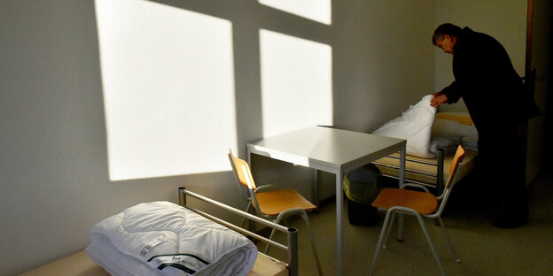Ein Mann richtet ein Zimmer in der Erstaufnahmeeinrichtung für Flüchtlinge ein Ein Mann richtet ein Zimmer in der Erstaufnahmeeinrichtung für Flüchtlinge ein